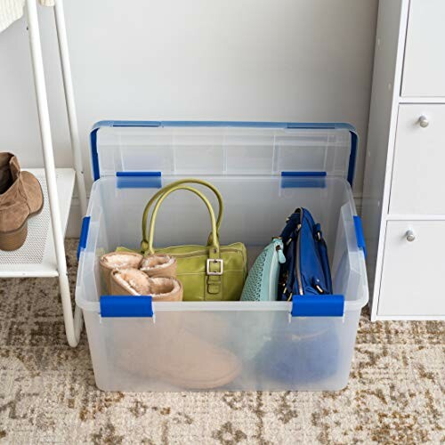 Clear plastic storage bin with handbags and boots inside.